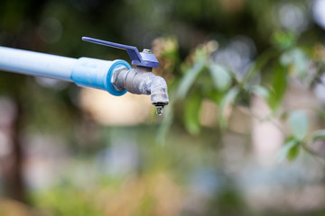 Old faucet with water drop