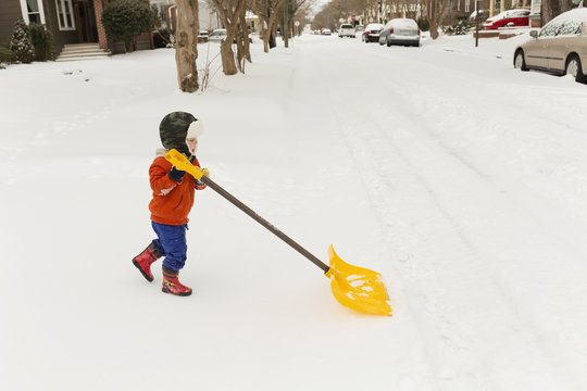 Small boy shoveling snow
