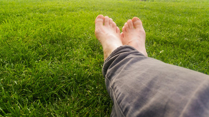 Barefoot on green grass under the sunlight
