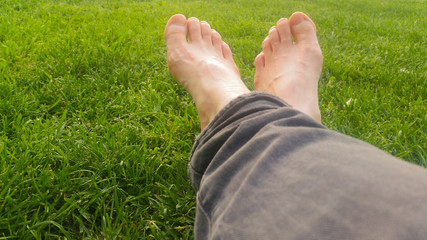 Barefoot on green grass under the sunlight
