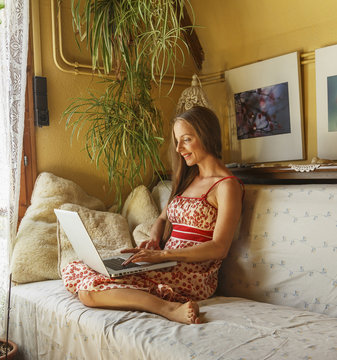 Caucasian woman using laptop on sofa