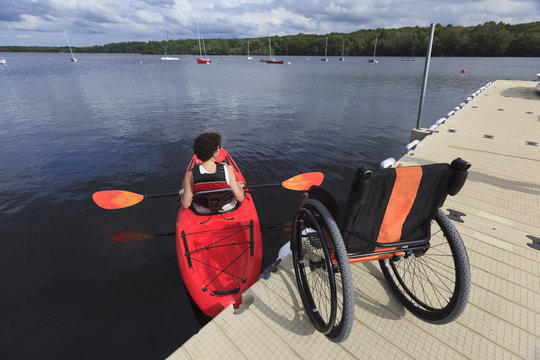 Paraplegic woman rowing kayak in river