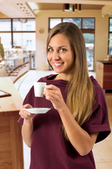Gorgeous happy woman holding teacup in bistro