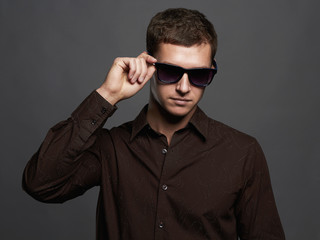Obraz premium fashion portrait of handsome man in sunglasses.Brutal guy
