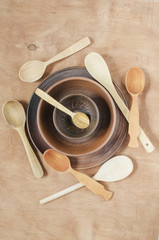 Home Kitchen Decor: the ceramic plates and wooden spoon on a wooden background. Top view. Rustic style.