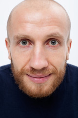 Satisfied man with a ginger beard looks in the frame