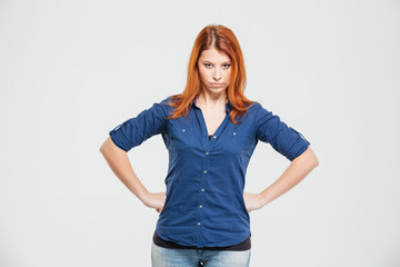 Angry irritated redhead young woman standing with hands on waist