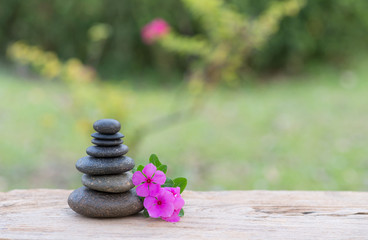 Purple flower and stone zen spa on wood with garden blurred back