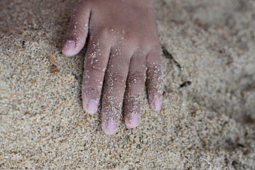 kids hand on sand