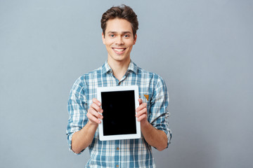 Smiling man showing blank tablet computer screen