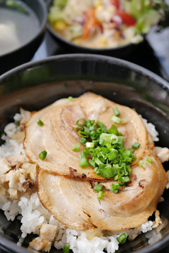 japanese rice bowl topped with sliced roasted pork