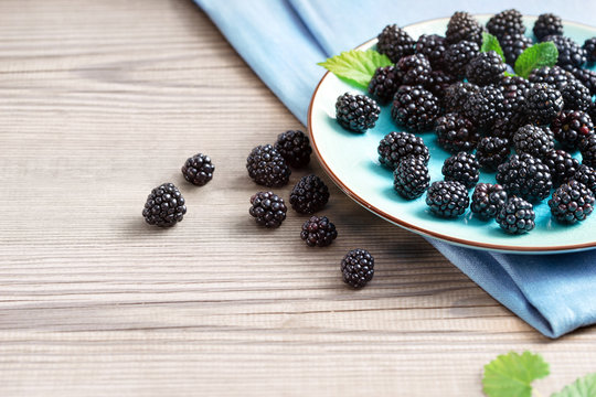 Ceramic plate with blackberries at old wooden table. Close up, high resolution product. Harvest Concept