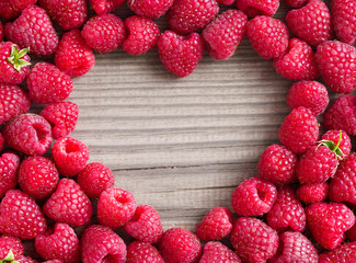 Heart shape made of premium raspberries on wooden background. Close up, top view, high resolution product. Harvest Concept © Romario Ien