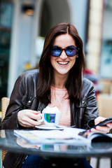 Young brunette woman sitting at a coffeeshop and relaxing