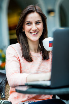 Young brunette woman sitting at a coffeeshop and relaxing