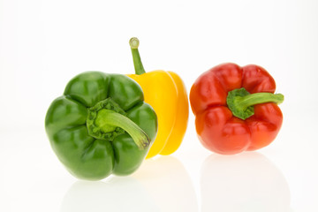 Yellow, green and red bell peppers, isolated on white background.