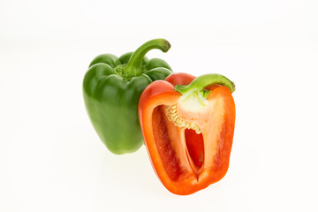 Fresh green and half cut red bell peppers, isolated on white background.