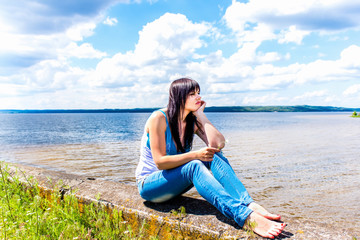 Fototapeta na wymiar Beautiful girl relaxing near the river