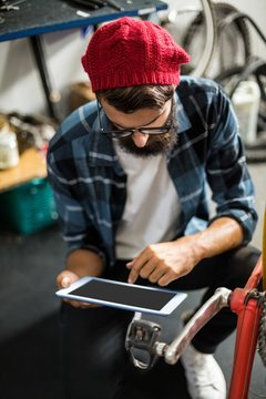 Bike mechanic looking at tablet computer