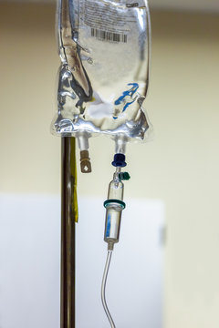 Close up of Intravenous bag on drip stand in a hospital ward. 