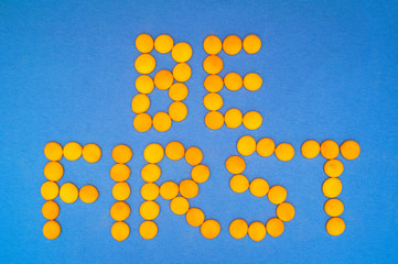 Be First, motivation quote. Letteras are mde of little yellow round on blue background