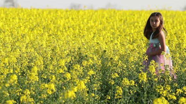 Happy Beauty young girl playing in yellow rape field in rural countryside. Portrait shot, Happy Freedom outdoors concept.