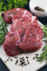 Beef, rosemary, pepper on chopping board of artificial stone
