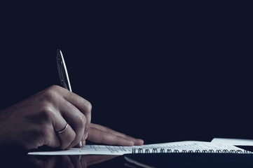 Close up Human Hand Signing on Formal Paper at the Table. Black