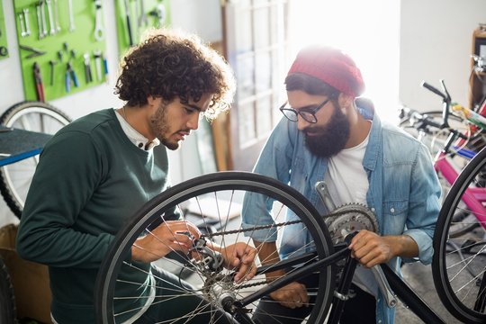 Mechanic repairing bike at workshop