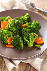 Obraz na płótnie Canvas Closeup shot of steamed carrots and broccoli on plate.