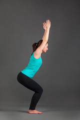 beautiful woman doing yoga utkatasana