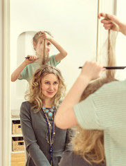 Naklejka premium Little girl doing funny hairstyle to her mother.