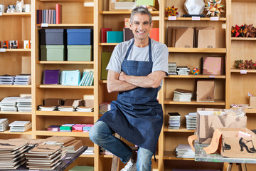 Smiling Salesman Standing Arms Crossed In Book Store