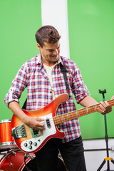Smiling Professional Playing Guitar In Recording Studio