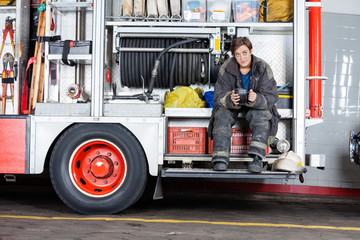 Fototapeta premium Thoughtful Firewoman Sitting In Truck
