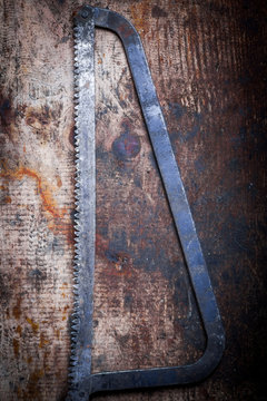 Hacksaw on wooden plank