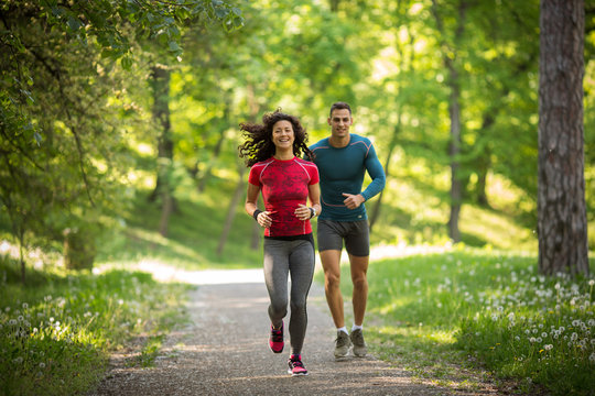 Young couple jogging at the woods.Green environment. 