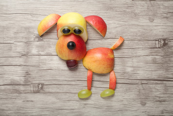 Dog made of apple on wooden background