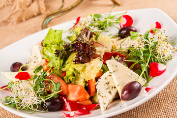 Salad with cheese, tomatoes and lettuce leaves