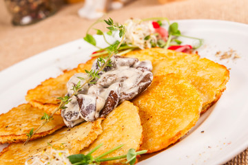Potato pancakes with mushrooms and sour cream