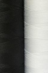 two black and white spools of thread close-up