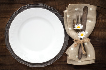 Table place setting with vintage silverware and plate with an empty tag for your text on rustic...