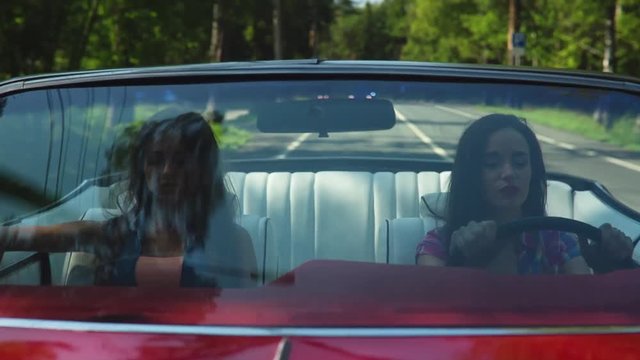Two Young Happy Girls Driving A Cabriolet