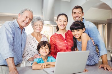 Fototapeta premium Portrait of happy family with laptop at home