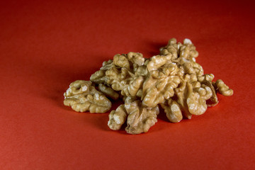 A handfull of wallnuts isolated on a red background