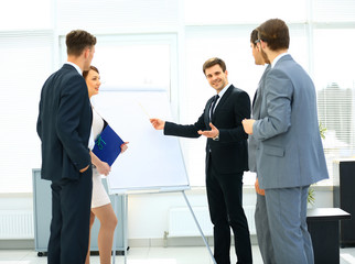 Workers at business meeting looking at presentation of financial reports in modern office