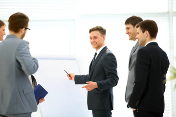 Workers at business meeting looking at presentation of financial reports in modern office