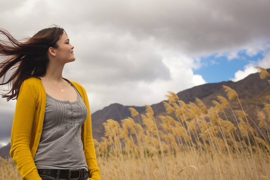 Beautiful young woman enjoys a breeze outdoors