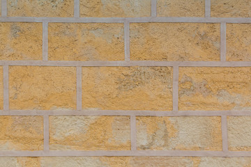 Pattern on the wall made as a fake full size bricks or blocks.