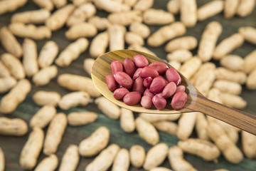 Peanuts in shells on wood background